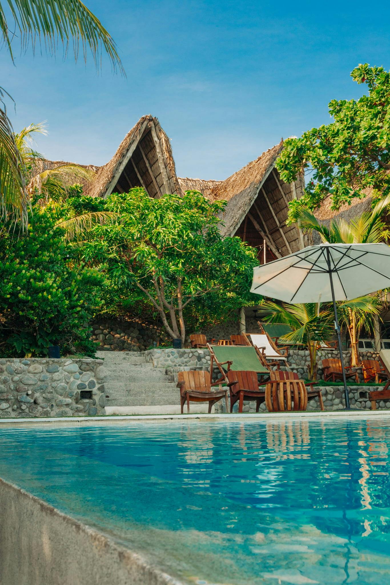 Relaxing poolside with umbrella and lounge chair, overlooking the restaurant.